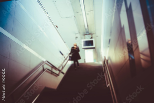 Blurred defocused vintage filtered person going downstairs in a
