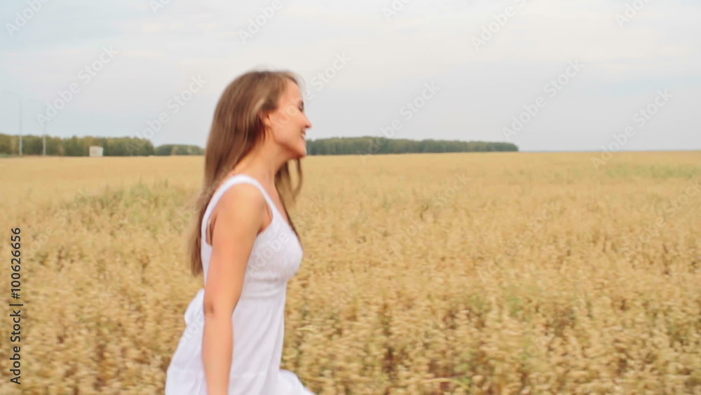 Joyful beautiful woman running through the field of rye Joyful beautiful woman running through the field of rye