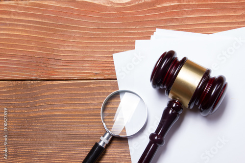 Law book with wooden judges gavel on table in a courtroom or law enforcement office.