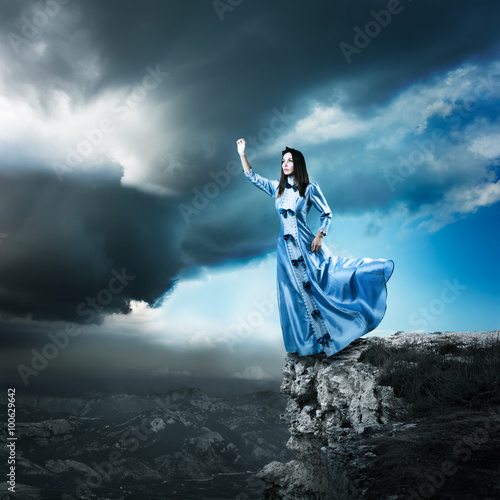 Woman in Blue Dress Reaching for the Light