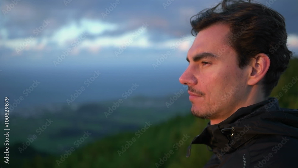Front look at young caucasian man staring into the sunset on Azores Island Front look at young caucasian man staring into the sunset on Azores Island