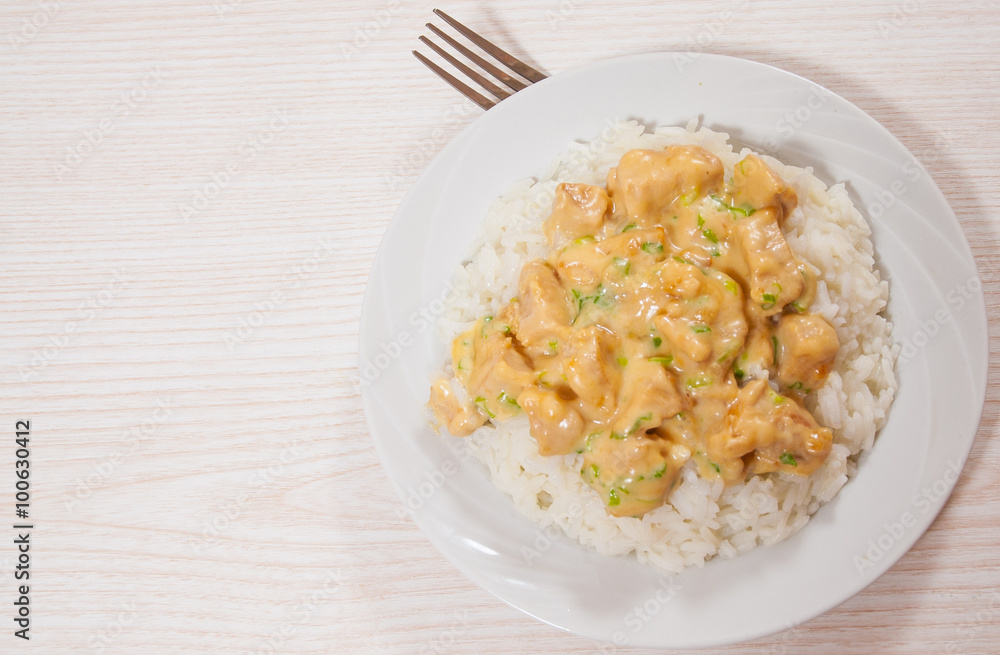 Pieces of chicken fillet and cheese sauce with rice