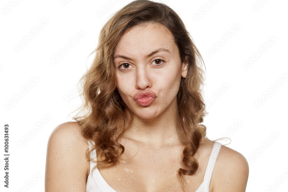 young woman without make-up with pursed lips young woman without make-up with pursed lips
