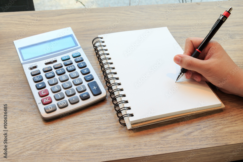 Women hands writing with pencil, notebook and Calculator Women hands writing with pencil, notebook and Calculator