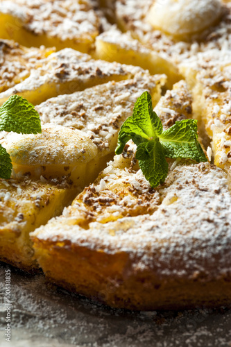 Pieces of pineapple pie with mint on baking paper
