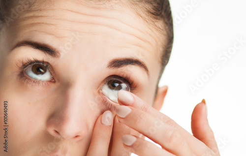 Woman putting contact lens in her eye