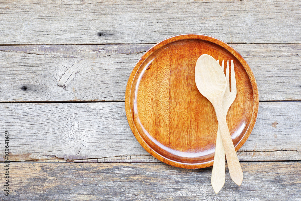 Wooden tray with wooden folk and spoon on wooden table Wooden tray with wooden folk and spoon on wooden table