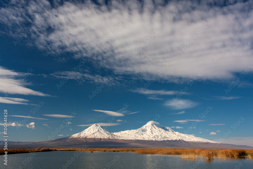 Fototapeta premium Snowy Ararat mountain in blue sky with foamy clouds