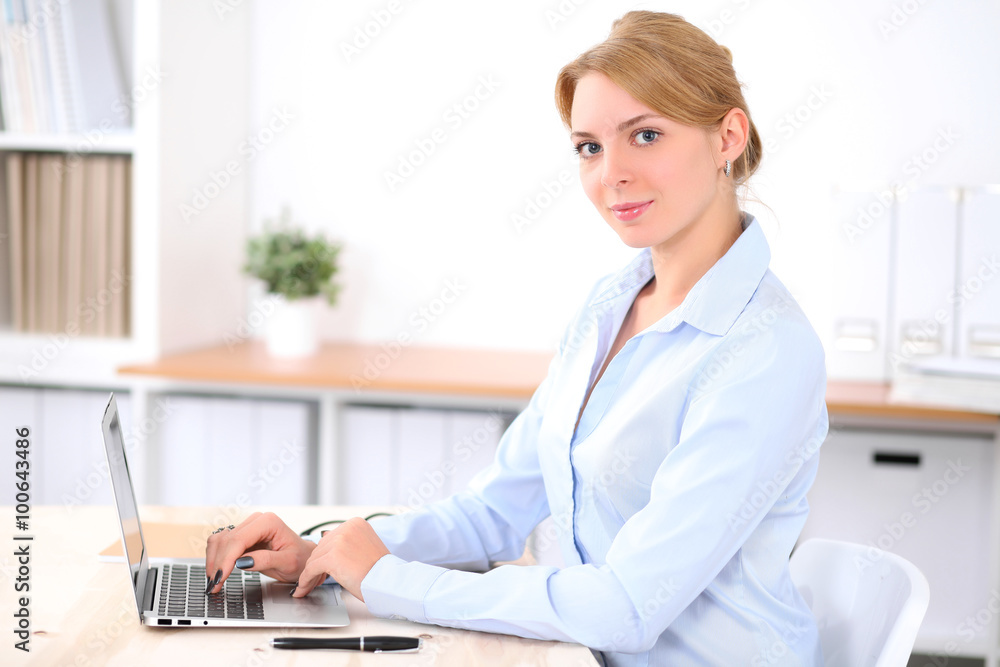 Young blonde business woman with laptop in the office. Business concept. Young blonde business woman with laptop in the office. Business concept.