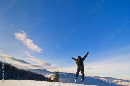 free happy man jumps on the top of mountain
