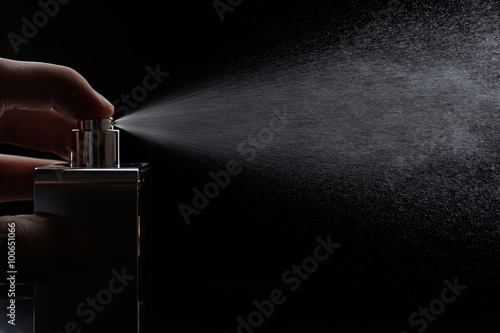 spray perfume on black photo