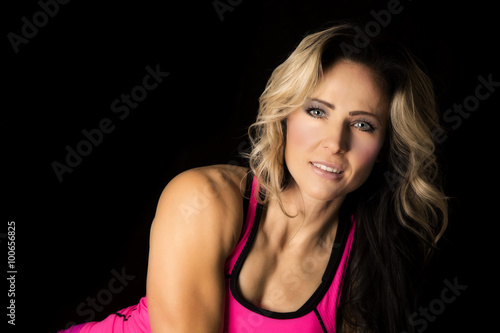 blond woman in pink on black upper body looking