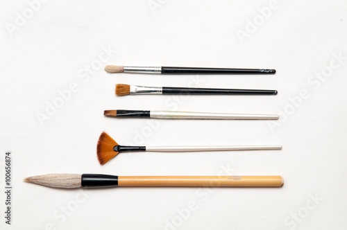 Artists brushes and pens displayed on isolated white background