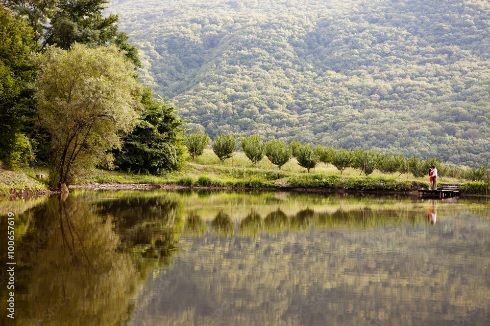 Fototapeta premium Couple in love on the shore of Lake Forest
