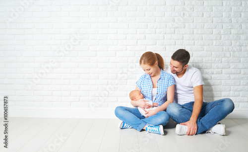 happy family mother, father of a newborn baby on floor near blan