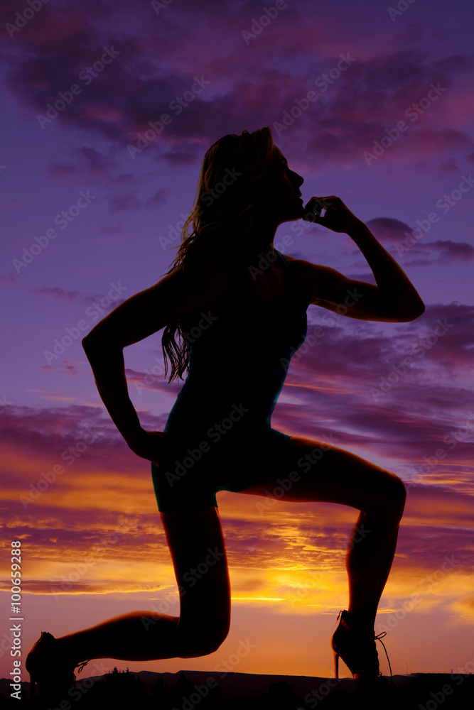 silhouette of a woman crouching on one knee