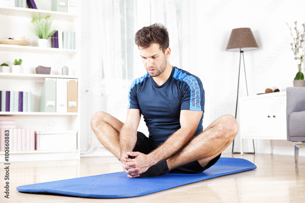 Athletic Man Doing Seated Adductor Stretch at Home