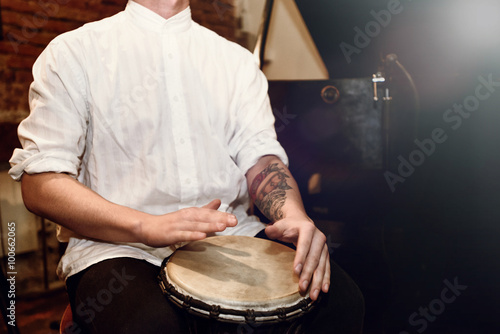 Fotografia, Obraz stylish percussionist playing on leather drum on a concert, hand