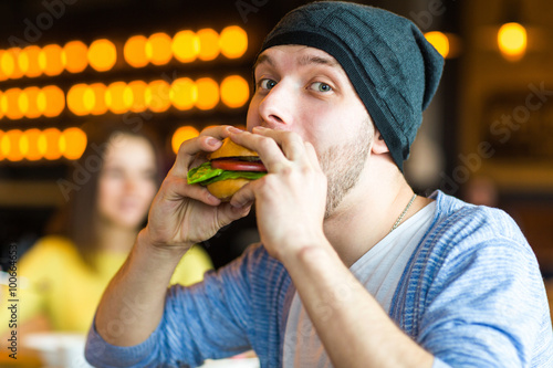 man in hands holds a burger. Man holding a burger and smiling