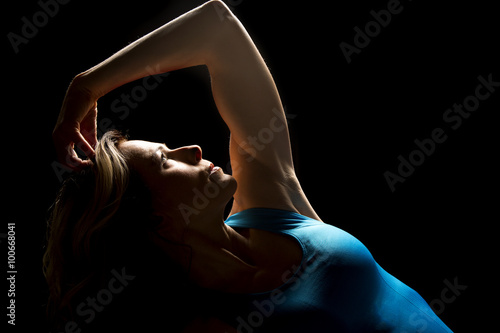 woman in blue tank top lean back hand on head highlighted Stock Photo