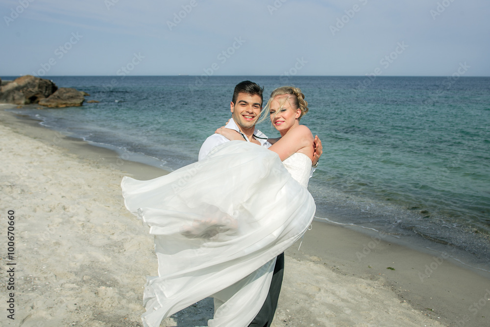 a young couple running at the beach, wedding at the sea, beautiful white wedding dress a young couple running at the beach, wedding at the sea, beautiful white wedding dress