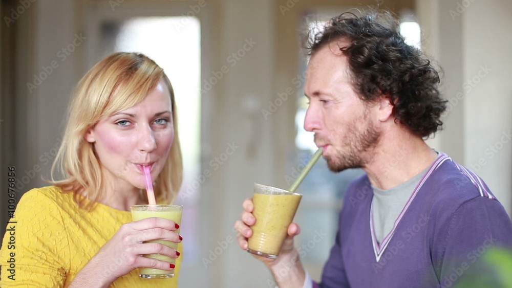 Happy couple toasting and drinking fruit smoothie Happy couple toasting and drinking fruit smoothie