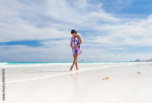 Pregnant woman walking on white beach © photopixel
