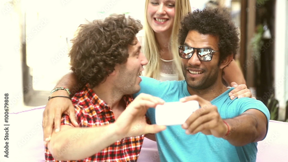 Two men and woman having fun taking spontaneous selfies Two men and woman having fun taking spontaneous selfies