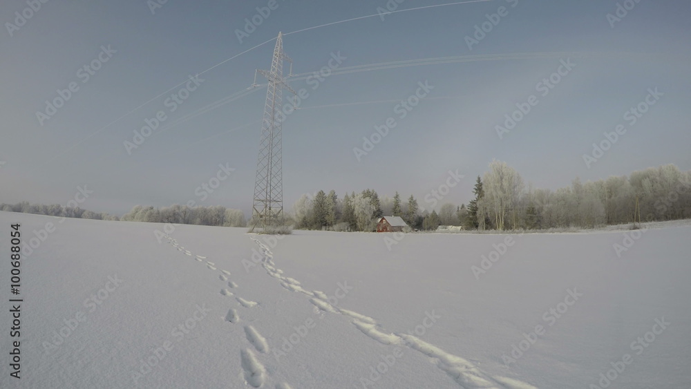 Landscape with electrical pylon and red ranch during snowdrift morning fog in fields by forest, time lapse 4K Landscape with electrical pylon and red ranch during snowdrift morning fog in fields by forest, time lapse 4K
