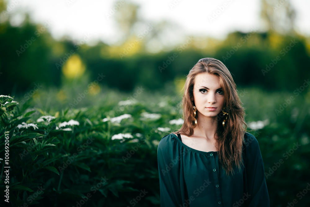 Beautiful young woman posing in a flowering spring park