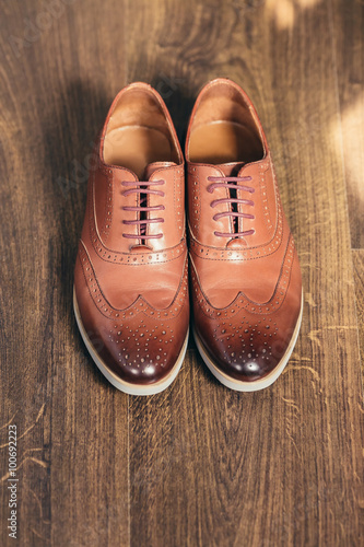 Brown grooms wedding shoes on wooden background
