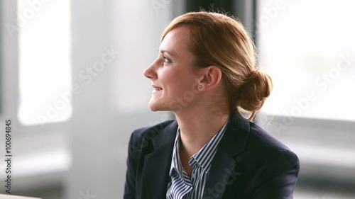 Young businesswoman listening and nodding during corporate presentation