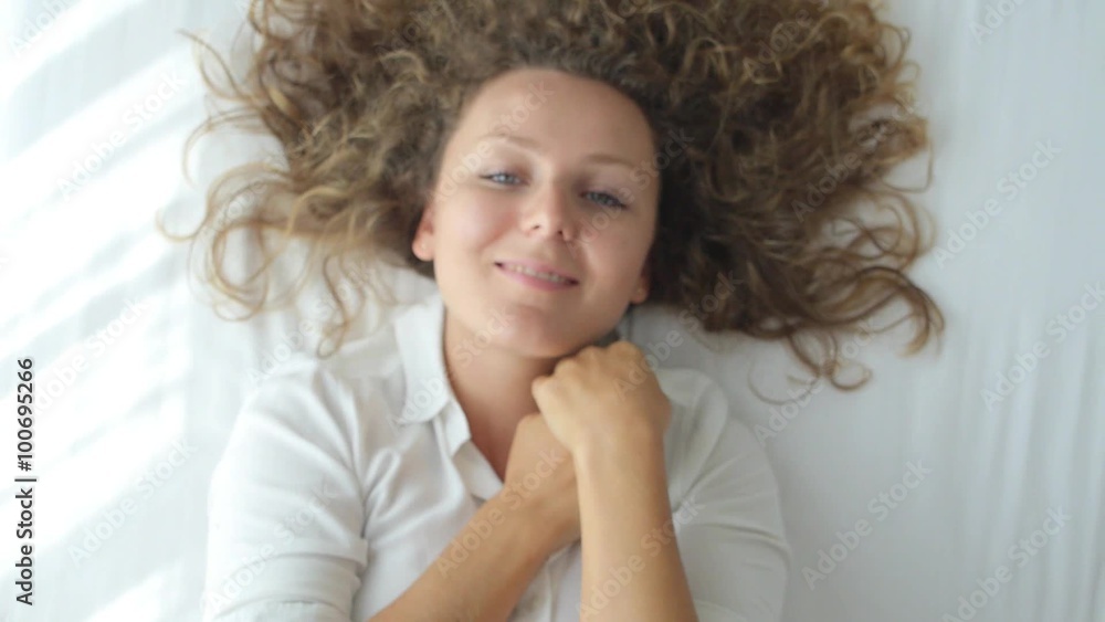 Young Sensual Woman Lying on Bed and Smiling Young Sensual Woman Lying on Bed and Smiling