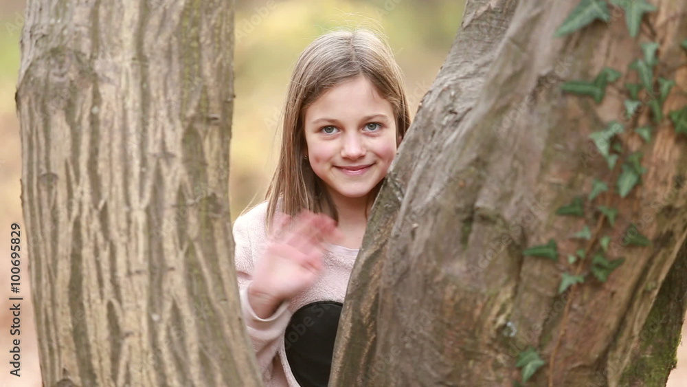 Girl standing by the tree and waving Girl standing by the tree and waving