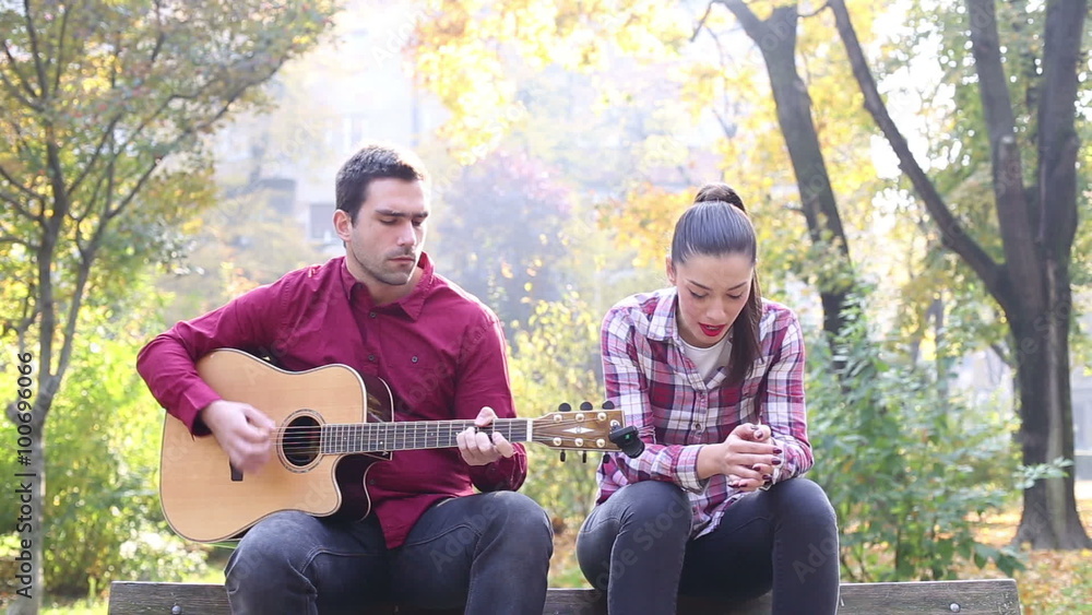 Man playing guitar while woman singing Man playing guitar while woman singing