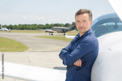 Portrait of pilot stood next to aircraft