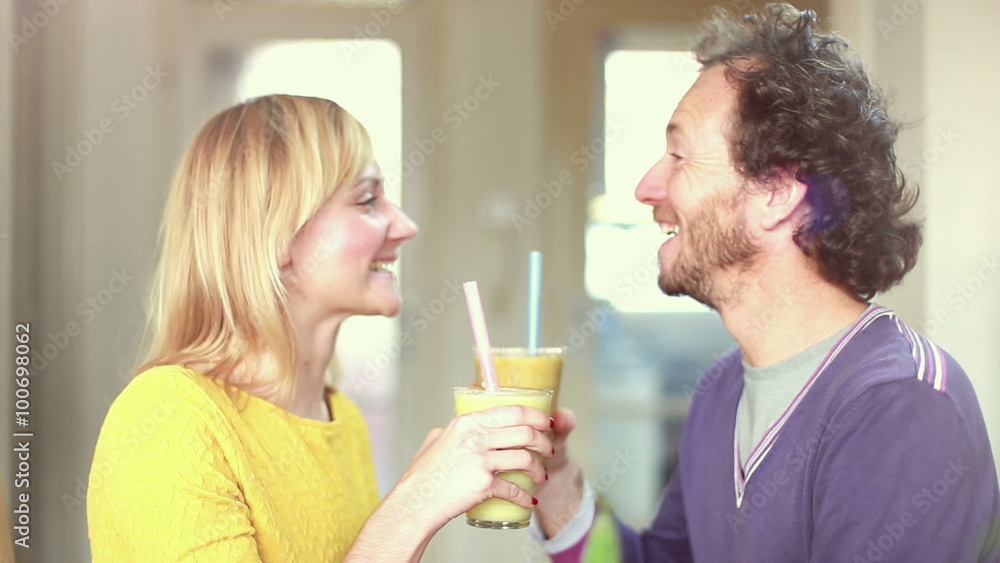 Happy couple toasting and drinking fruit smoothie Happy couple toasting and drinking fruit smoothie
