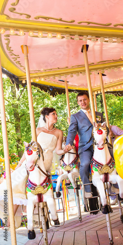 Wedding couple smiling in a carousel on her wedding day 