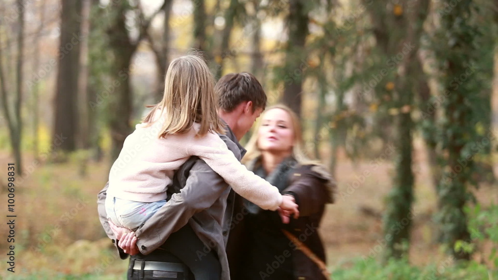 Family dancing in park, father carrying daughter on his back Family dancing in park, father carrying daughter on his back