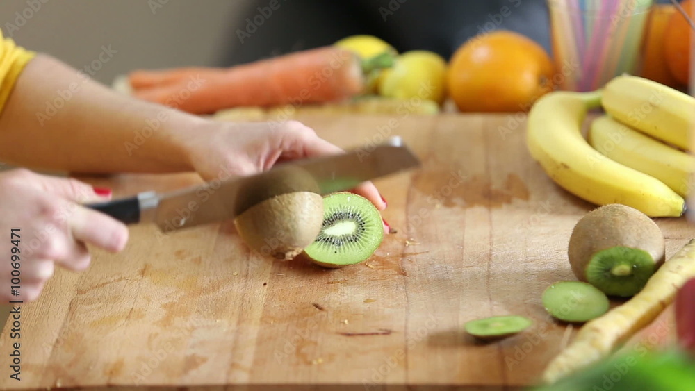 Woman cutting kiwi Woman cutting kiwi