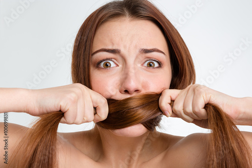 Scared frightened young woman covered mouth with her long hair