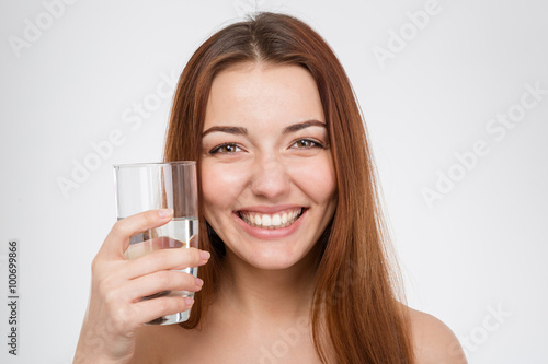 Cheerful attractive woman holding glass of water