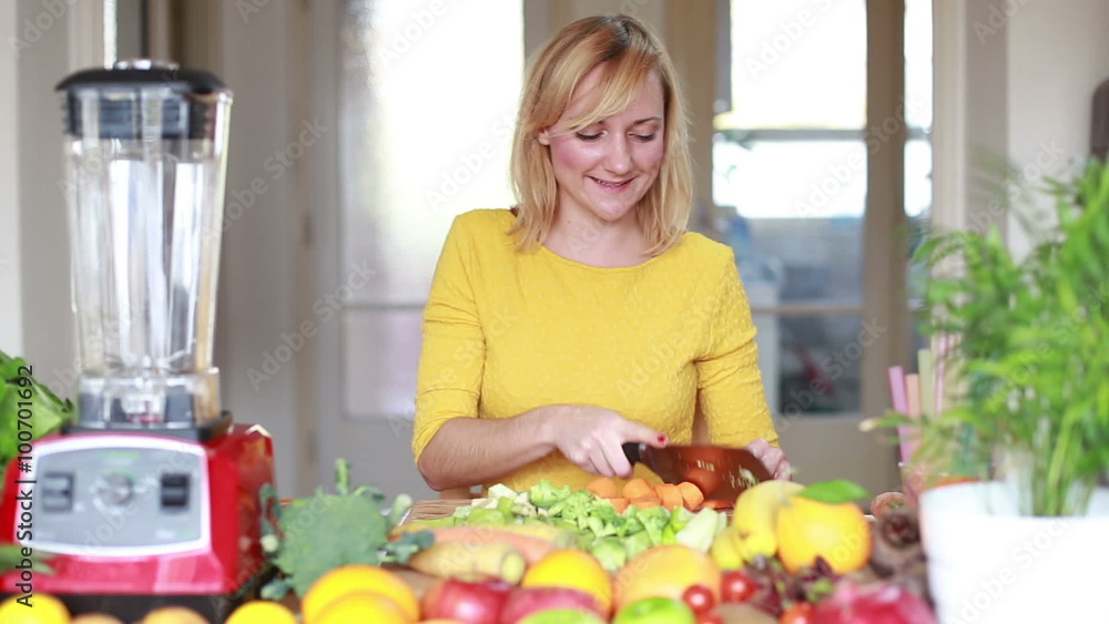 Woman cutting carrot into slices on chopping board Woman cutting carrot into slices on chopping board
