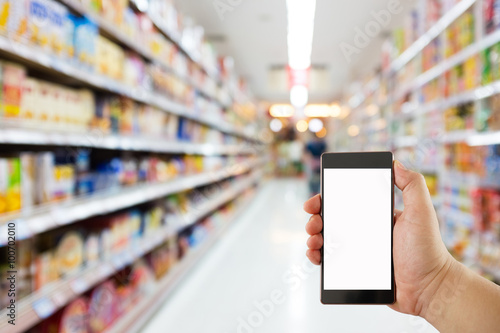 hand holding mobile phone on Supermarket blur background, business concept