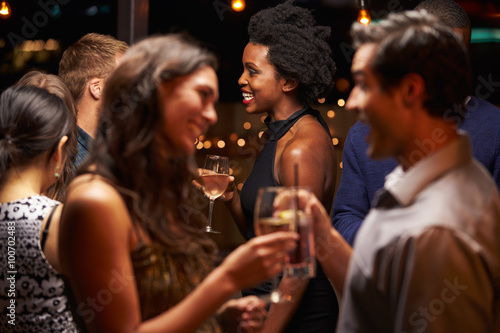 Couples Chatting And Drinking At Evening Party