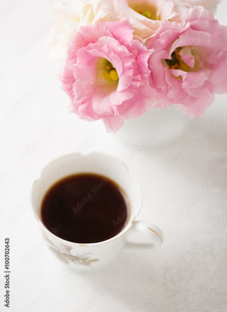 Obraz premium Still life with cup of coffee and flowers (Eustoma). Selective focus. Shallow depth of field.