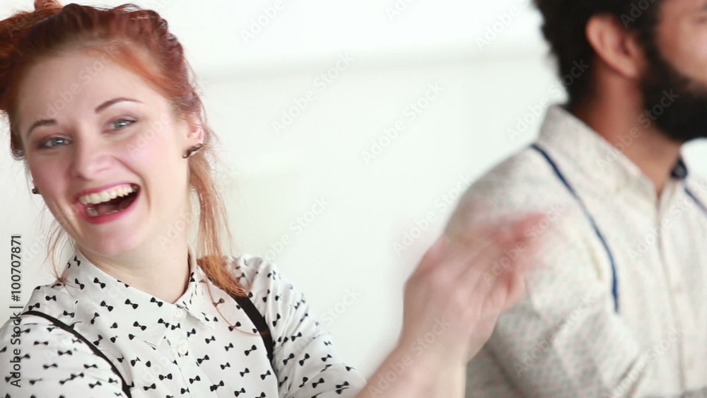 Woman applauding during presentation, male colleague in background