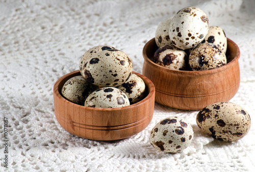 Quail eggs in wooden bowls on the table