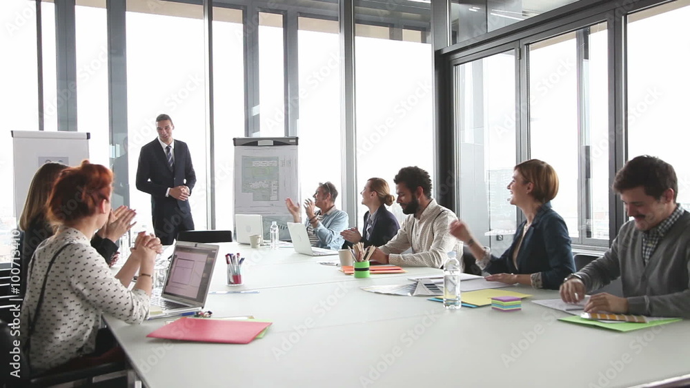 Colleagues applauding director during a meeting in conference room Colleagues applauding director during a meeting in conference room