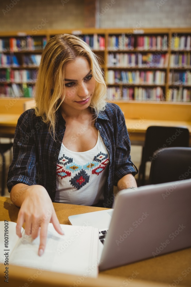Smiling student working while using her laptop Smiling student working while using her laptop